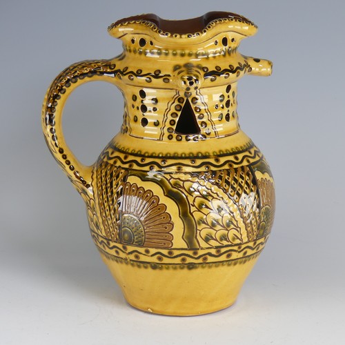 64 - Nick Juniper (20th century) a Bideford pottery Puzzle Jug, decorated with slipware with sunflowers a... 