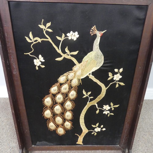 556 - An Arts and Crafts oak framed fire Screen, with centrally embroidered panel depicting a peacock, W 6... 