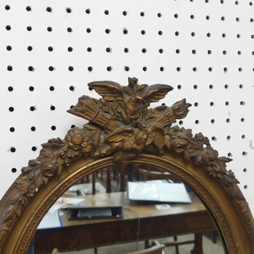 553 - A near pair of 19th century style giltwood wall Mirrors, both of oval form and with carved pediments... 