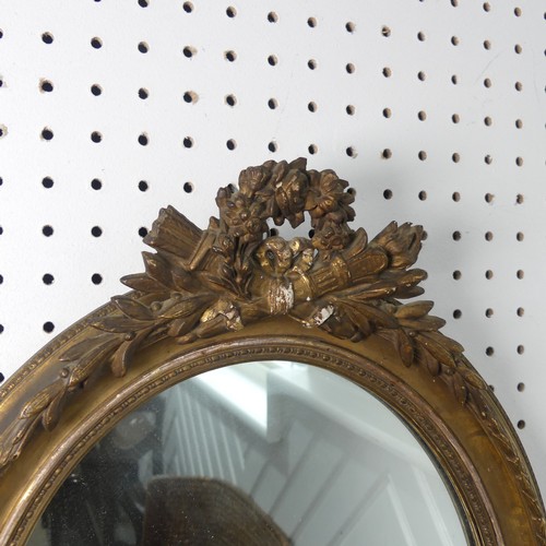 553 - A near pair of 19th century style giltwood wall Mirrors, both of oval form and with carved pediments... 