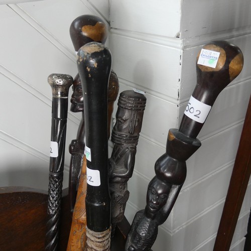 502 - A carved Tribal walking Stick, H 84 cm, together with four other carved Tribal walking Sticks and a ... 