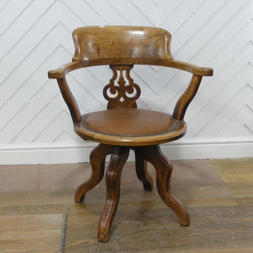 642 - An early 20th century mahogany swivel captains desk Chair, the shaped headrest over circular upholst... 