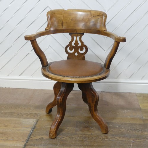 642 - An early 20th century mahogany swivel captains desk Chair, the shaped headrest over circular upholst... 