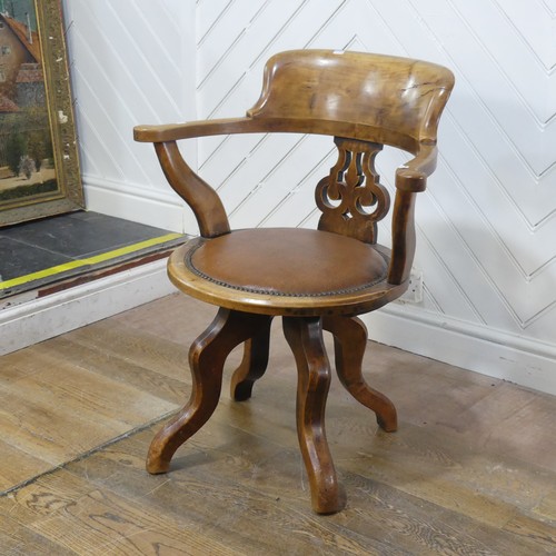 642 - An early 20th century mahogany swivel captains desk Chair, the shaped headrest over circular upholst... 