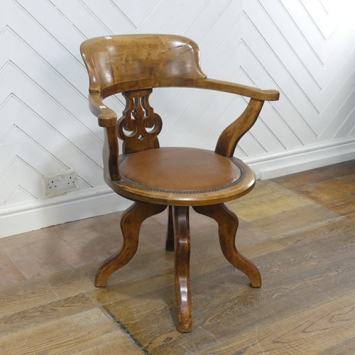 642 - An early 20th century mahogany swivel captains desk Chair, the shaped headrest over circular upholst... 