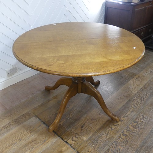 659 - A 20th century oak extending dining Table, with one additional leaf, circular top raised on central ... 