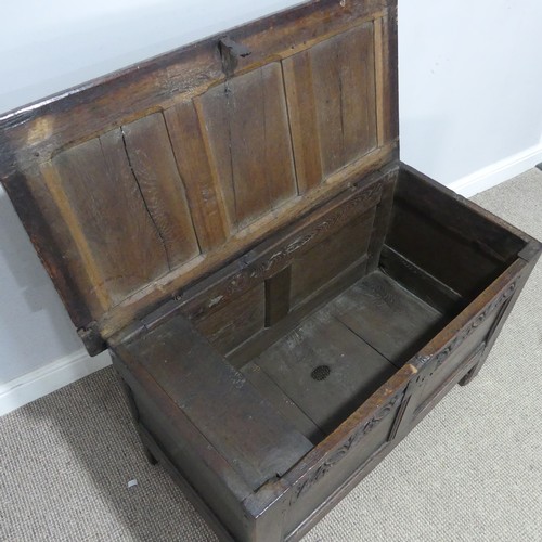 684 - An 18th century oak Coffer, of small proportions, the paneled top with pin hinges, above carved frie... 