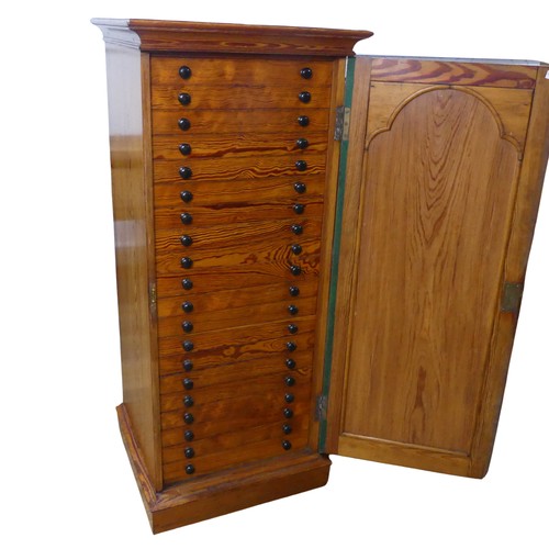 682 - An early 20th century pitch pine specimen/collectors Cabinet, the oak door concealing twenty slender... 