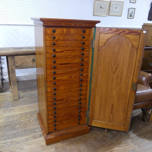 682 - An early 20th century pitch pine specimen/collectors Cabinet, the oak door concealing twenty slender... 