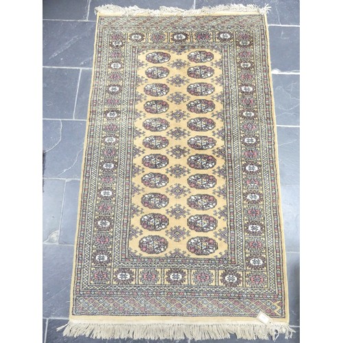 703 - Tribal Rugs: a buff ground Bokhara rug, wool pile on a cotton base, needs cleaning otherwise in good... 