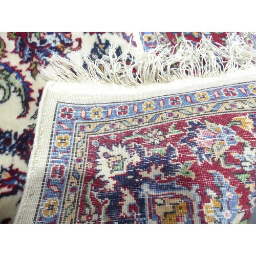 704 - Tribal Rugs; a Persian Isfahan rug, finely knotted wool pile on cotton base, cream ground within a r... 