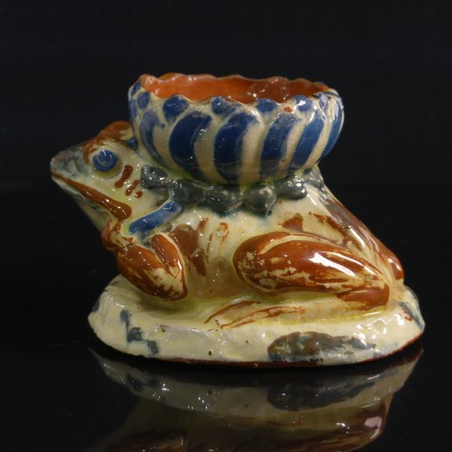 76 - A C. H. Brannam pottery Candleholder modelled as a Frog, in forward leaning pose with leg clutching ... 