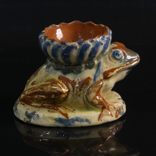 76 - A C. H. Brannam pottery Candleholder modelled as a Frog, in forward leaning pose with leg clutching ... 