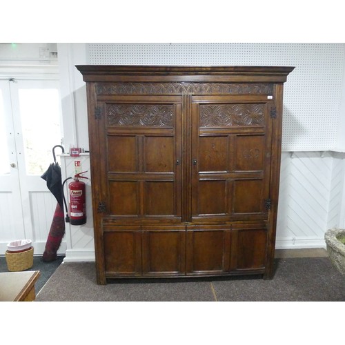 666 - A 17th century and later carved oak hall Cupboard, the carved and moulded cornice over two large pan... 