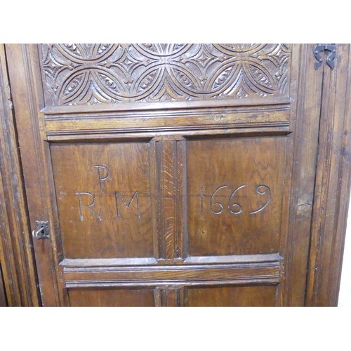 666 - A 17th century and later carved oak hall Cupboard, the carved and moulded cornice over two large pan... 