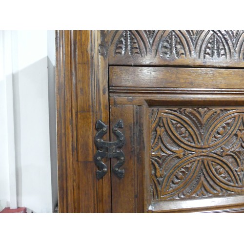 666 - A 17th century and later carved oak hall Cupboard, the carved and moulded cornice over two large pan... 