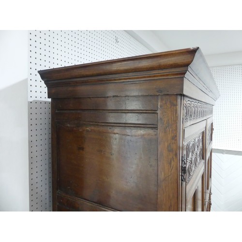 666 - A 17th century and later carved oak hall Cupboard, the carved and moulded cornice over two large pan... 