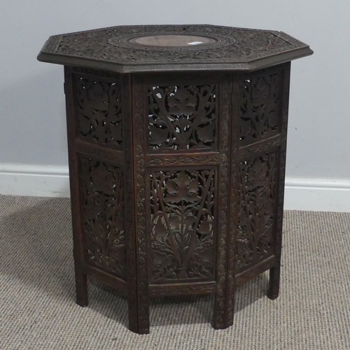 606 - An Anglo-Indian style carved occasional Table, with carved octagonal top supported on folding sides,... 