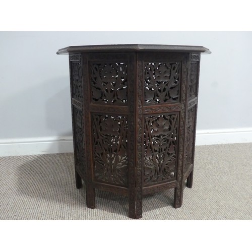 606 - An Anglo-Indian style carved occasional Table, with carved octagonal top supported on folding sides,... 