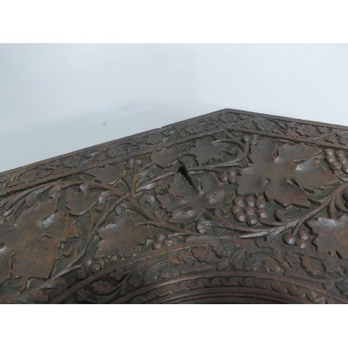 606 - An Anglo-Indian style carved occasional Table, with carved octagonal top supported on folding sides,... 