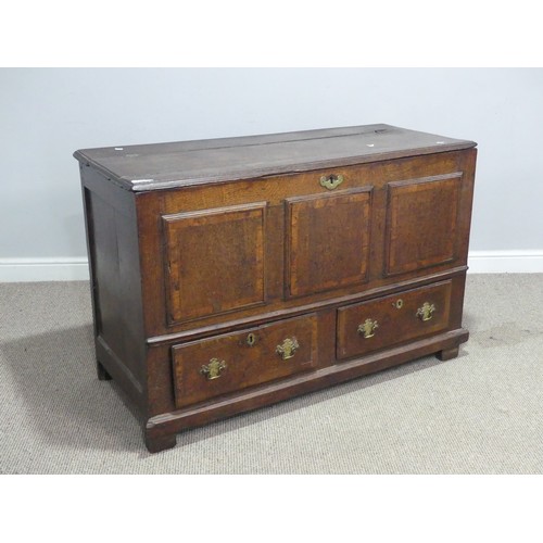 635 - An 18th century oak mule Chest, the hinged top over paneled sides and two drawers, raised on stump f... 