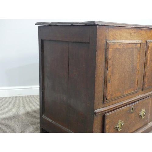 635 - An 18th century oak mule Chest, the hinged top over paneled sides and two drawers, raised on stump f... 