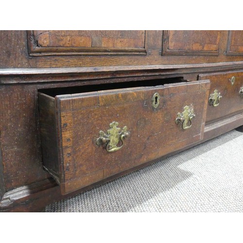 635 - An 18th century oak mule Chest, the hinged top over paneled sides and two drawers, raised on stump f... 