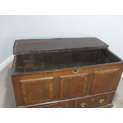 635 - An 18th century oak mule Chest, the hinged top over paneled sides and two drawers, raised on stump f... 