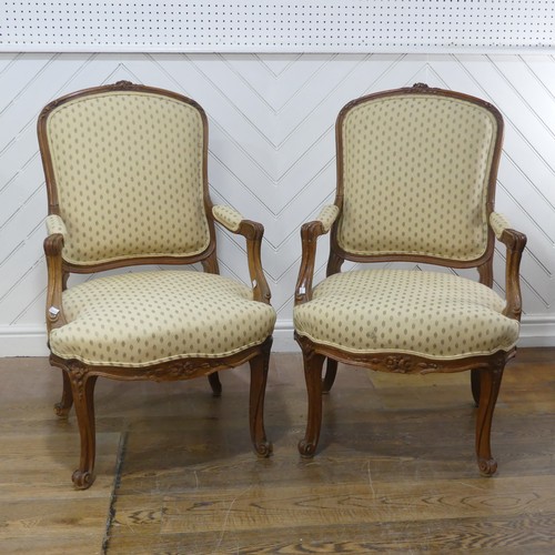 696 - A pair of French Louis XV style walnut Armchairs, the upholstered backrest and seat flanked by scrol... 