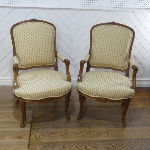 696 - A pair of French Louis XV style walnut Armchairs, the upholstered backrest and seat flanked by scrol... 