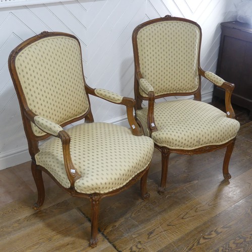 696 - A pair of French Louis XV style walnut Armchairs, the upholstered backrest and seat flanked by scrol... 