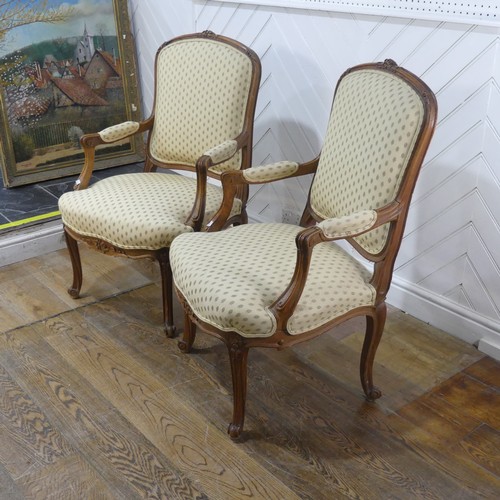 696 - A pair of French Louis XV style walnut Armchairs, the upholstered backrest and seat flanked by scrol... 