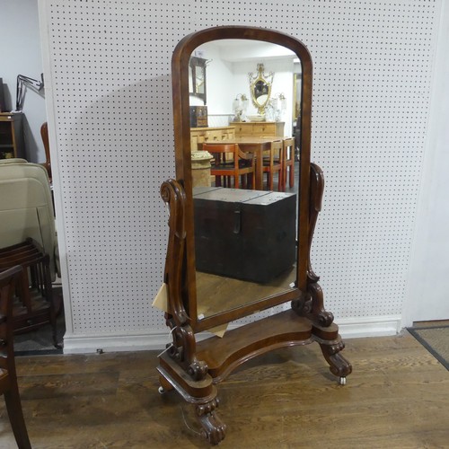 683 - A large Victorian mahogany cheval Mirror, the arched mirror flanked by carved and scrolled supports,... 