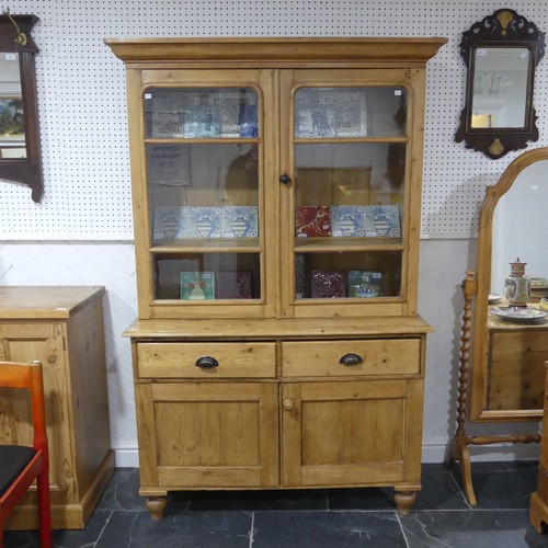 688 - A Victorian pine Dresser, the moulded cornice over two glazed doors, concealing shelves, raised on b... 