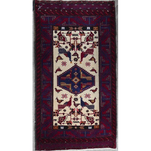 710 - Tribal Rugs: a Persian 'animal' rug, the cream and red ground woven with stylised peacocks and birds... 