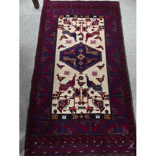 710 - Tribal Rugs: a Persian 'animal' rug, the cream and red ground woven with stylised peacocks and birds... 