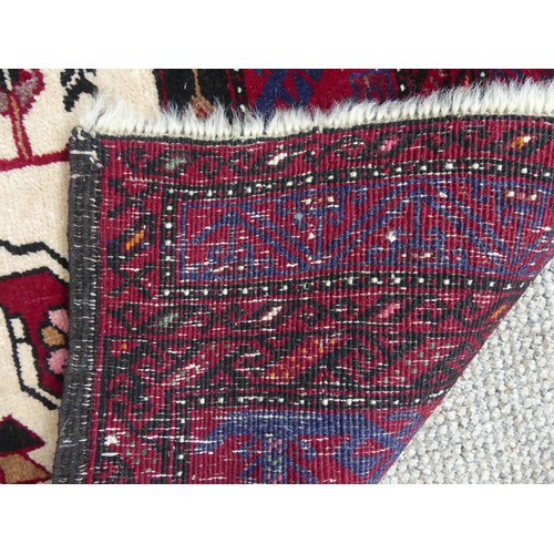 710 - Tribal Rugs: a Persian 'animal' rug, the cream and red ground woven with stylised peacocks and birds... 