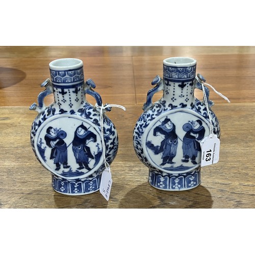 163 - A pair of Chinese blue and white porcelain Moon Vases, with central depiction of two figures, enclos... 