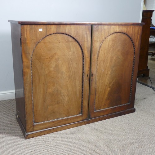 502 - An early 19thC mahogany low Cupboard, with two arched cupboard doors, concealing shelf, raised on pl... 