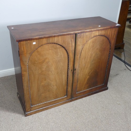 502 - An early 19thC mahogany low Cupboard, with two arched cupboard doors, concealing shelf, raised on pl... 