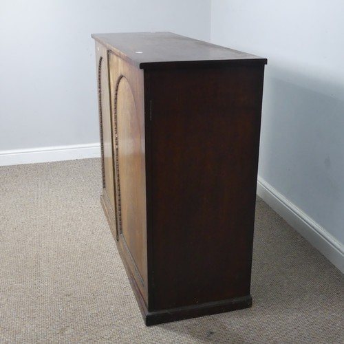 502 - An early 19thC mahogany low Cupboard, with two arched cupboard doors, concealing shelf, raised on pl... 