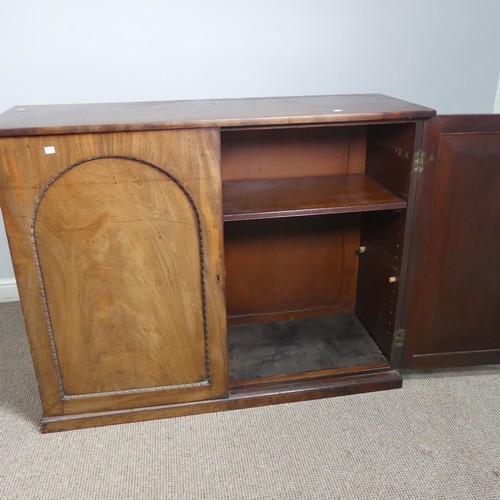 502 - An early 19thC mahogany low Cupboard, with two arched cupboard doors, concealing shelf, raised on pl... 