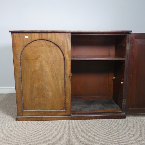 502 - An early 19thC mahogany low Cupboard, with two arched cupboard doors, concealing shelf, raised on pl... 