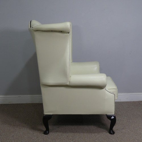 522 - A cream leather button and wingback Armchair, W 89 cm x H 90 cm x D 90 cm.