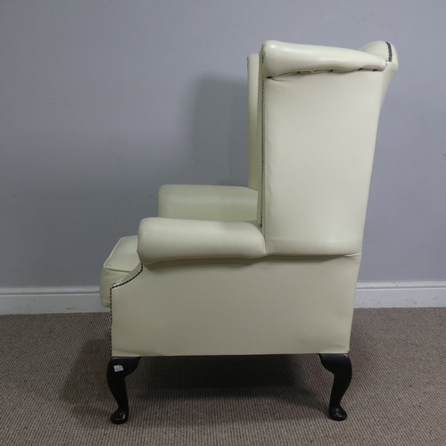 522 - A cream leather button and wingback Armchair, W 89 cm x H 90 cm x D 90 cm.