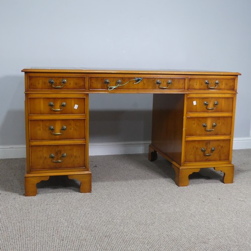 525 - A Brights of Nettlebed hardwood pedestal Desk, the top inset with a three sectional gilt tooled leat... 