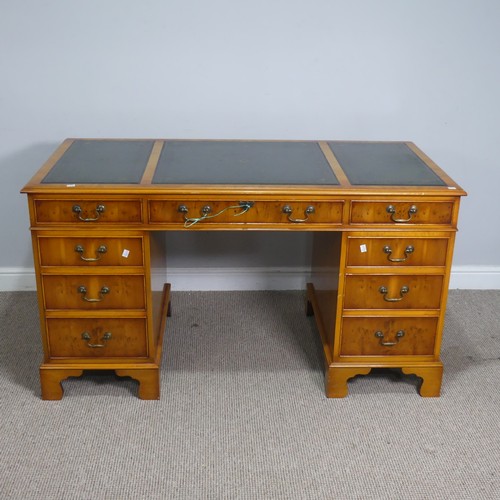 525 - A Brights of Nettlebed hardwood pedestal Desk, the top inset with a three sectional gilt tooled leat... 