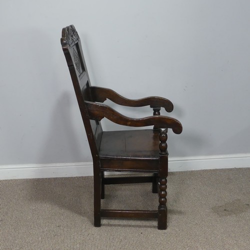 538 - A 17th century oak wainscot Chair, the shaped headrest with carved details, over square seat flanked... 