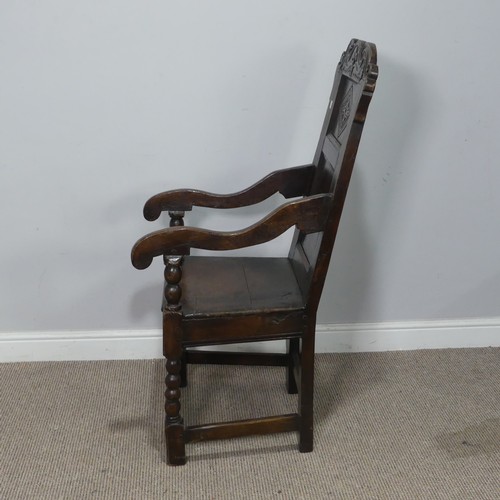 538 - A 17th century oak wainscot Chair, the shaped headrest with carved details, over square seat flanked... 