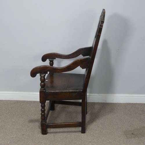 538 - A 17th century oak wainscot Chair, the shaped headrest with carved details, over square seat flanked... 